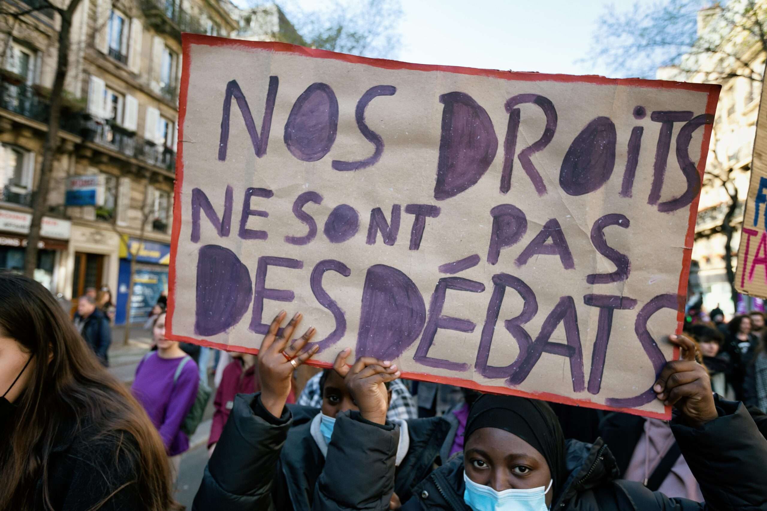 Deux manifestantes avec une pancarte avec le slogan "Nos droits ne sont pas des debats".