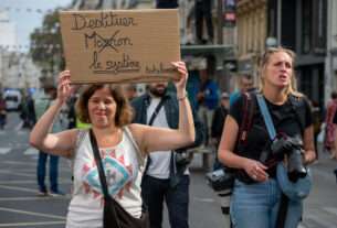 Manifestante tenant un panneau "destituer le système"