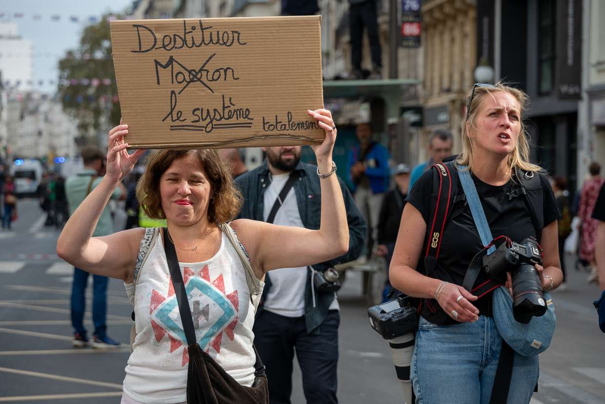 Manifestante tenant un panneau "destituer le système"